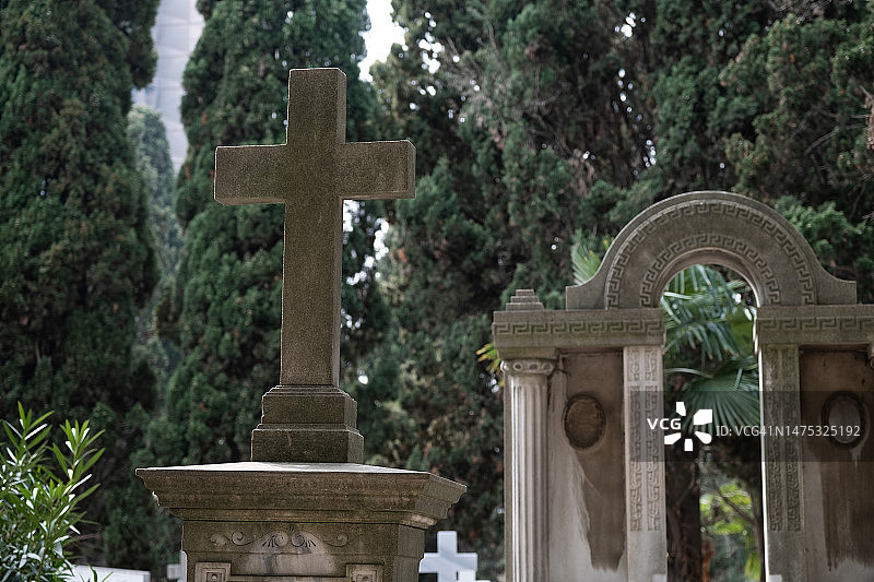 城市公墓：无人看管的旧坟墓，石头墓碑和金属十字架图片素材