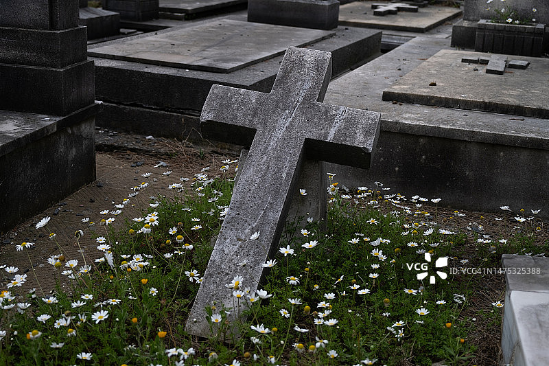 城市公墓：无人看管的旧坟墓，石头墓碑和金属十字架图片素材
