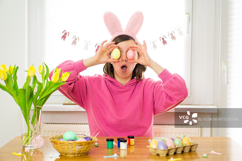 年轻女子戴兔耳朵彩绘复活节彩蛋图片素材