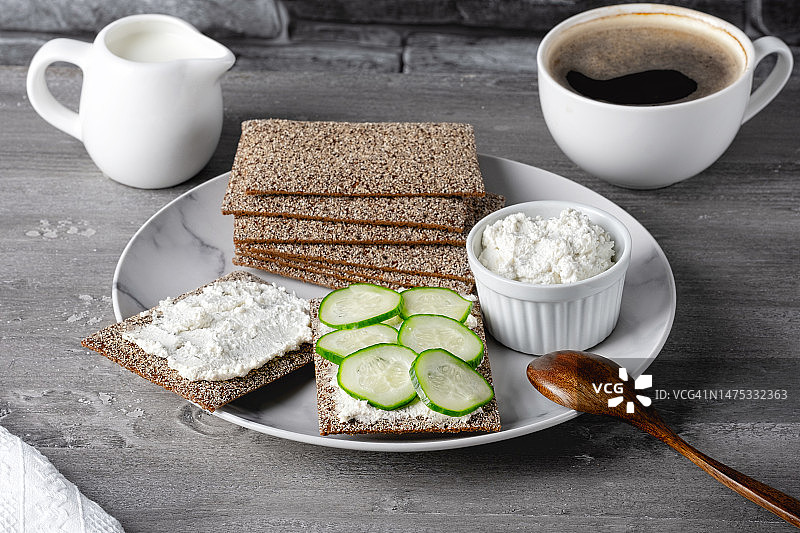 自制脆面包吐司，配农家干酪、黄瓜和咖啡，放在木桌上，斯塔夫罗波尔，斯塔夫罗波尔边疆区，俄罗斯。图片素材