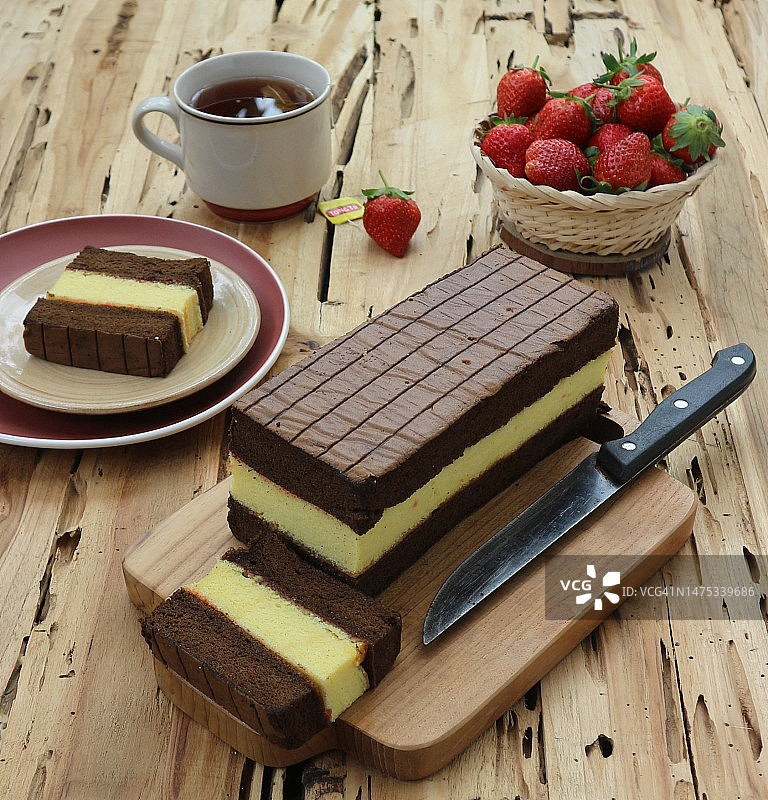 木桌上的巧克力蛋糕和一杯茶图片素材