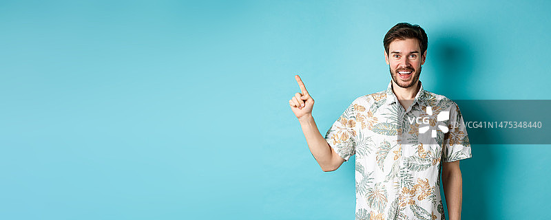 身穿夏威夷衬衫的快乐年轻人指向左边，展示图片素材