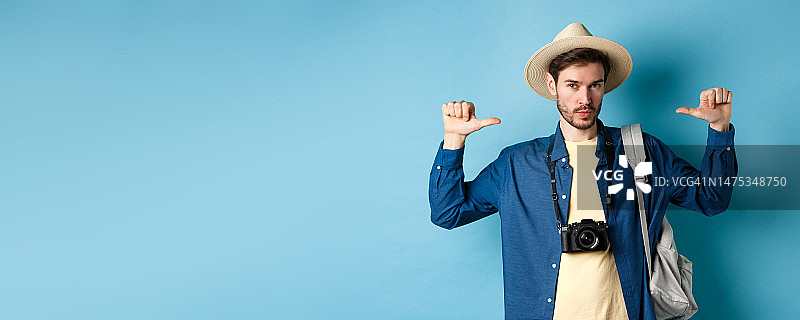 戴着夏日帽子的自信英俊的男人，指向自己图片素材