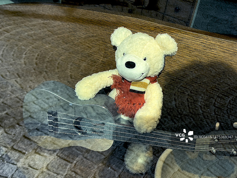 戴围巾的泰迪熊弹吉他图片素材