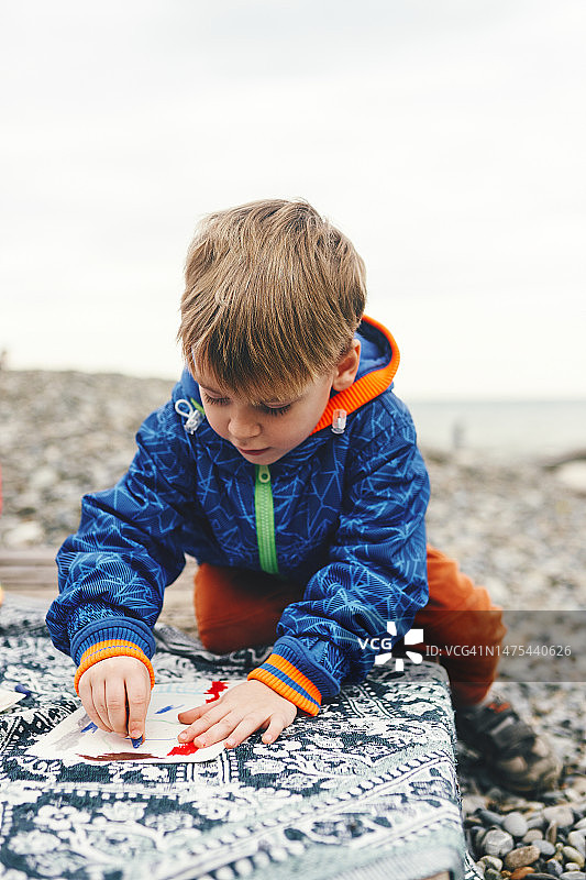 男孩在海边绘画图片素材