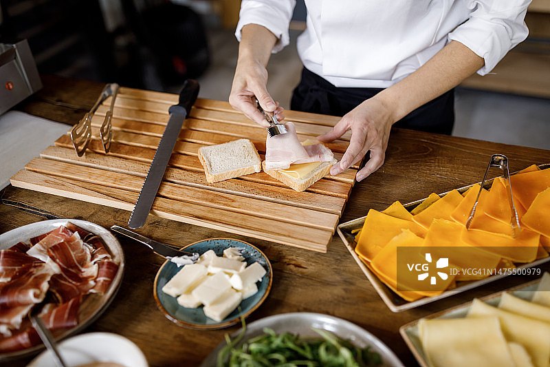 在餐厅厨房准备三明治的年轻女职员图片素材