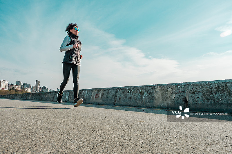 运动苗条女人沥青路低视角图片素材