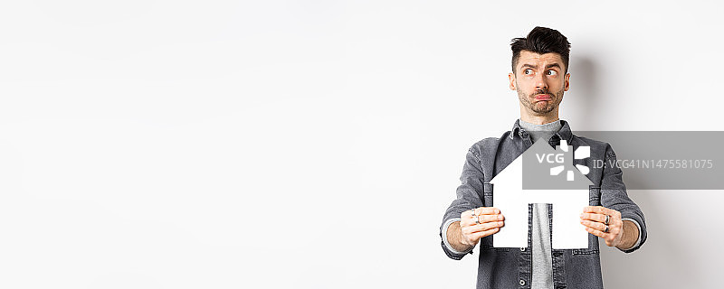 房地产和房屋保险概念：犹豫不决的男人若有所思地看向一边图片素材