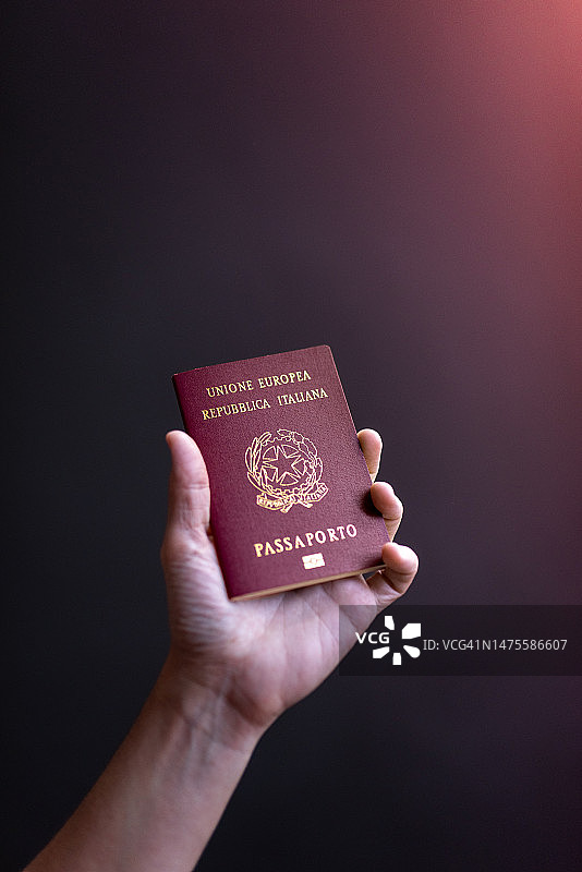 手持护照的裁剪图，背景为黑色，意大利图片素材