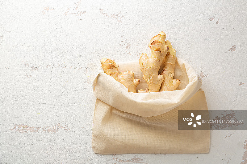 浅色背景上棉布袋里的生姜俯视图图片素材