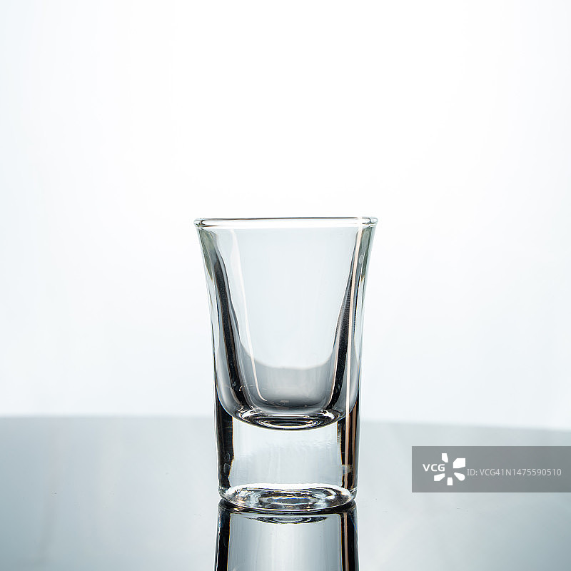 白色背景下桌上的空玻璃杯特写图片素材
