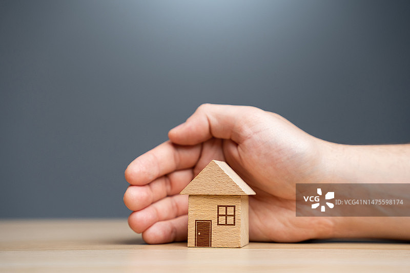 在乌克兰，一人在桌子上拿着房屋模型的局部照片图片素材