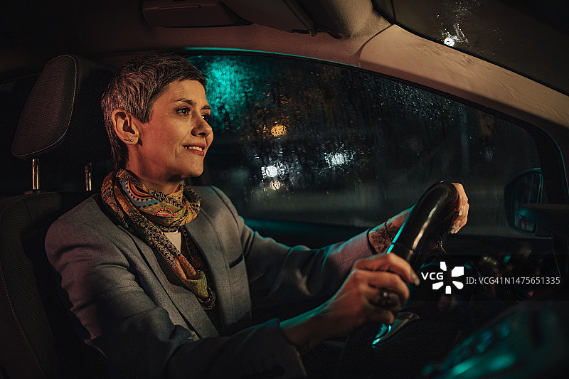夜晚，驾驶汽车的中年妇女图片素材