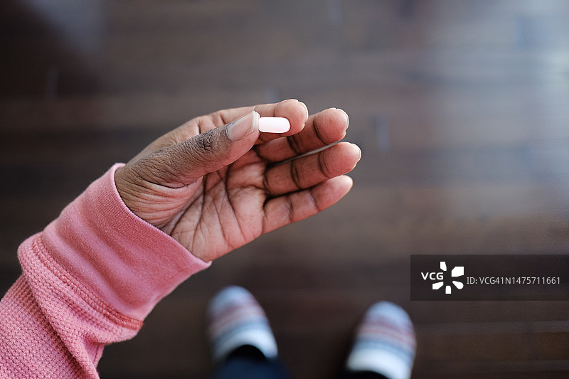 女人拿着一颗药丸图片素材