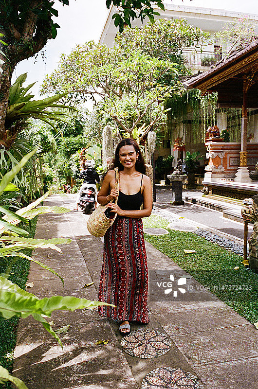 站在人行道上手提包微笑的女人图片素材