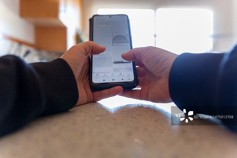 特写：女人在家用智能手机和朋友聊天图片素材