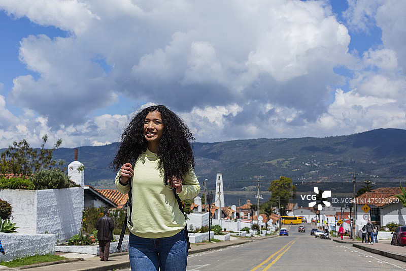 在名为瓜塔维塔的哥伦比亚城镇的街道上，行走并了解其伟大历史的拉丁裔女性图片素材
