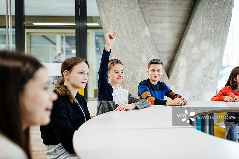 在科技讲座上举手提问的男孩图片素材