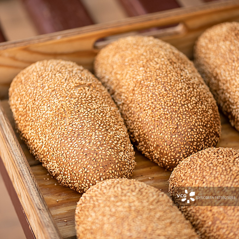 木托盘里的芝麻面包，全麦麸皮面包，健康杂粮烘焙食品，特写，柔焦，俯视图片素材