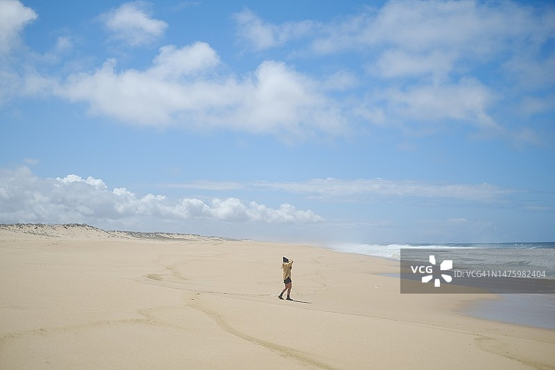 年轻女摄影师探索偏远海滩图片素材