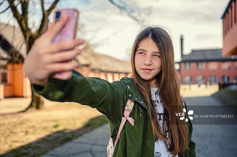 用手机自拍的微笑小学生图片素材