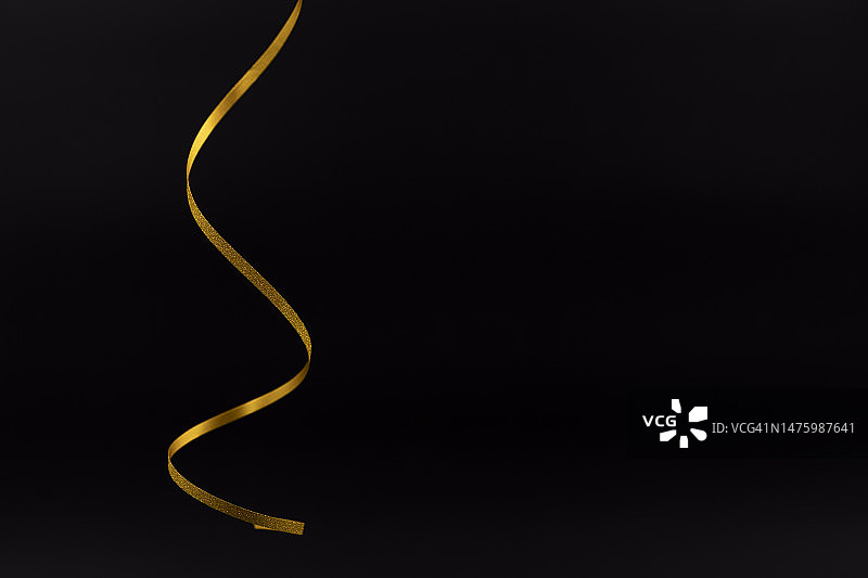 黑色背景上的金色金属闪光丝带图片素材