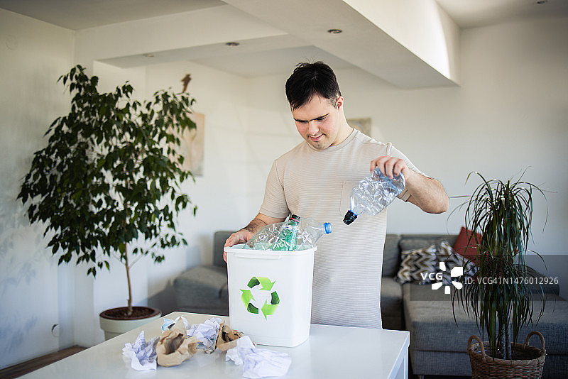 快乐的男人在家回收塑料图片素材