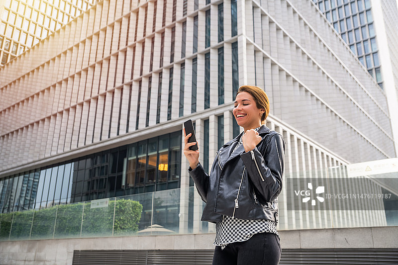 在手机上收到好消息的拉丁美洲女人图片素材