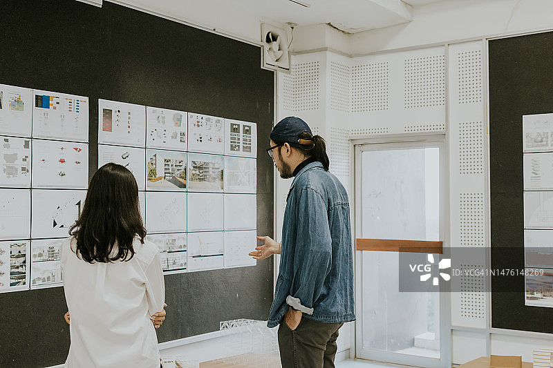 亚洲建筑师合伙人咨询并讨论建筑系学生的可持续设计论文作品展览图片素材
