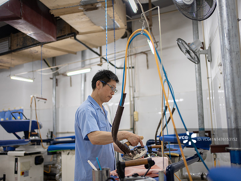 男人熨衣服图片素材