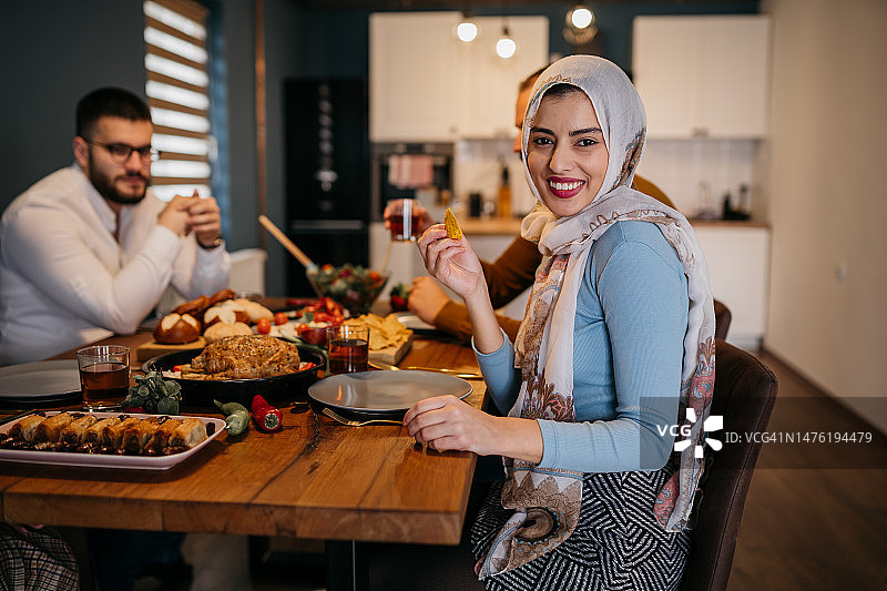 年轻的穆斯林女人和她的家人一起享用午餐图片素材