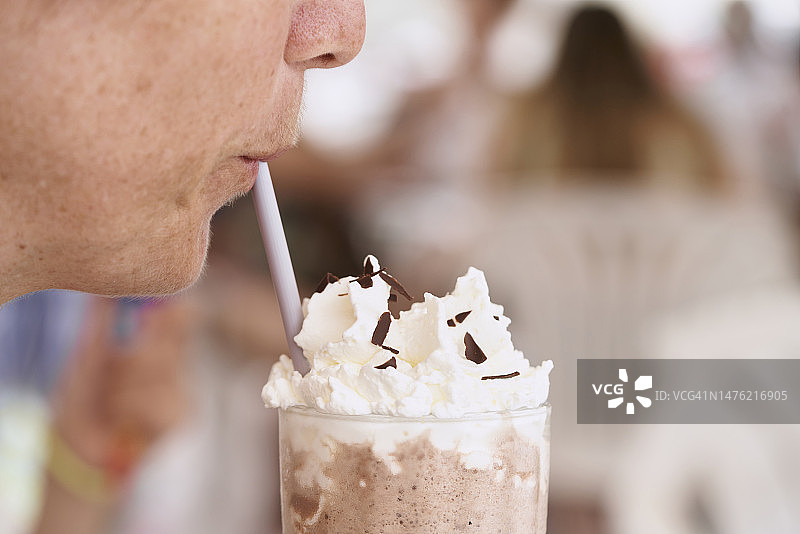 在餐厅里，女人喝星冰乐的嘴唇特写，侧视图图片素材