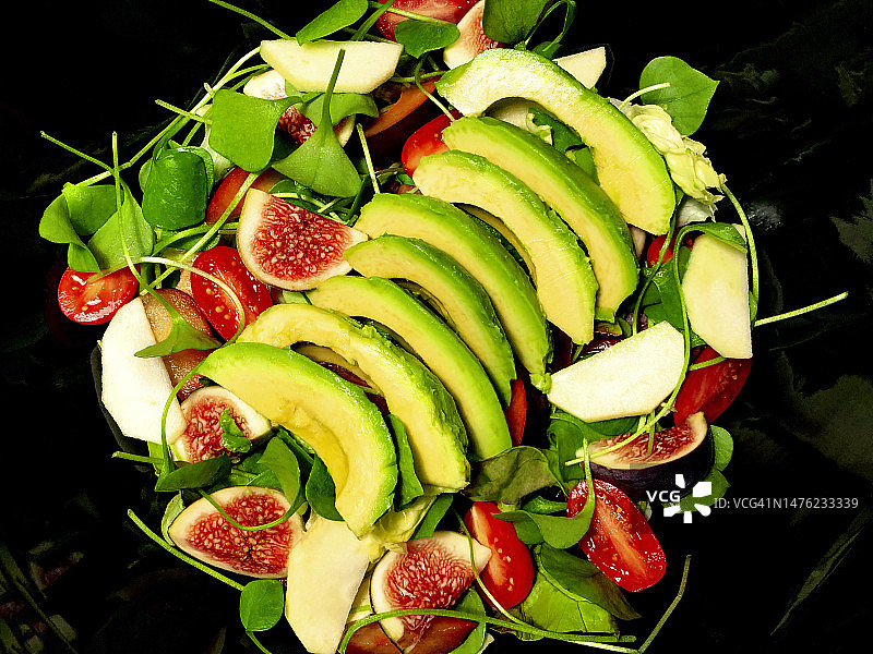 新鲜沙拉特写：鳄梨、无花果、苹果、聚合菜、番茄图片素材