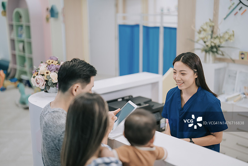 中国儿科护士协助患者及父母在诊所登记图片素材