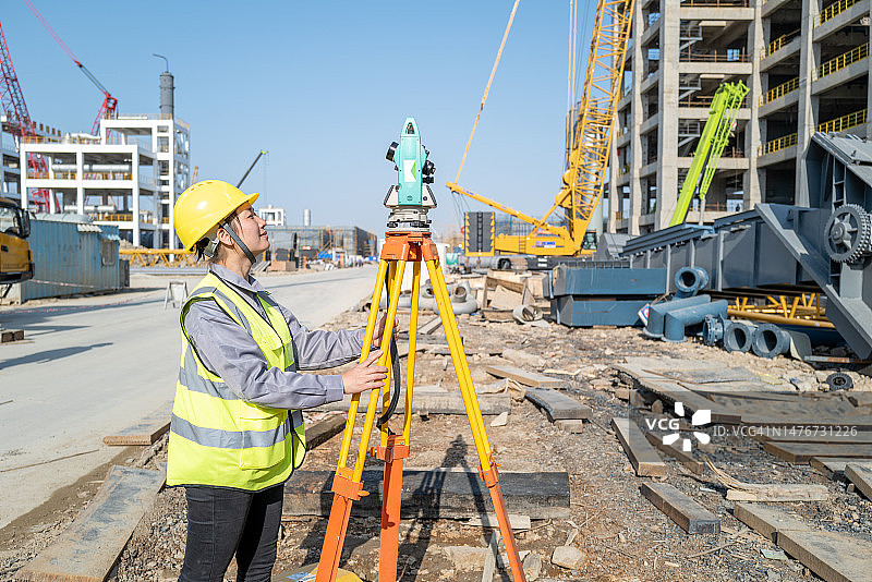 一位美丽的女工程师在化工厂的建筑工地上进行测量图片素材