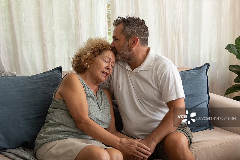 儿子安慰悲伤的母亲图片素材