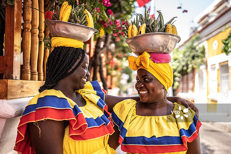 在哥伦比亚卡塔赫纳的街道上交谈和拥抱的帕伦克妇女图片素材