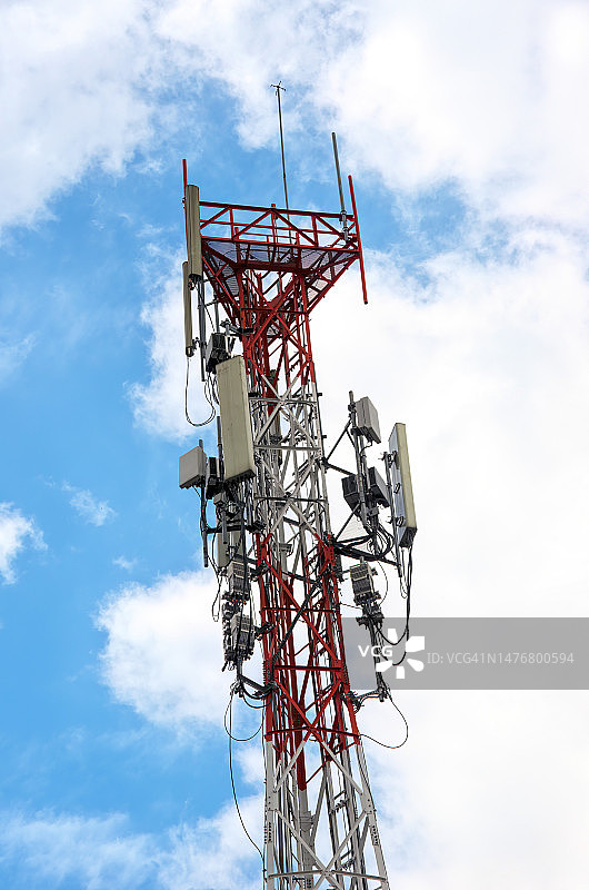 楼顶上的手机信号增强器和卫星天线塔，背景是多云的天空图片素材