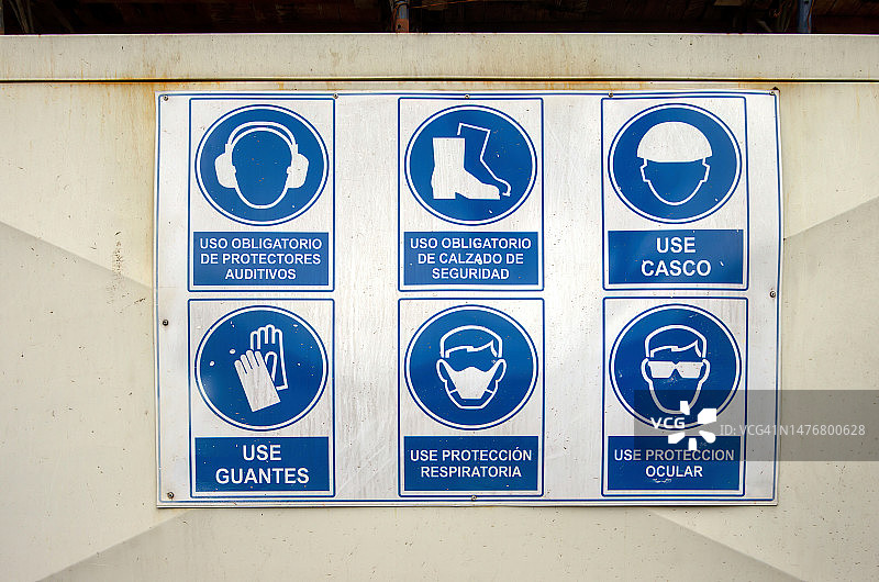 建筑工地上的西班牙语信息标志，声明了工人必须遵守的职业健康安全规章和程序图片素材