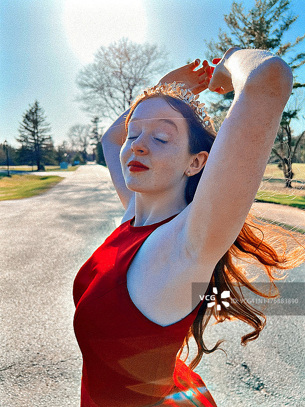 红衣舞会皇后在户外风和阳光下摆姿势图片素材