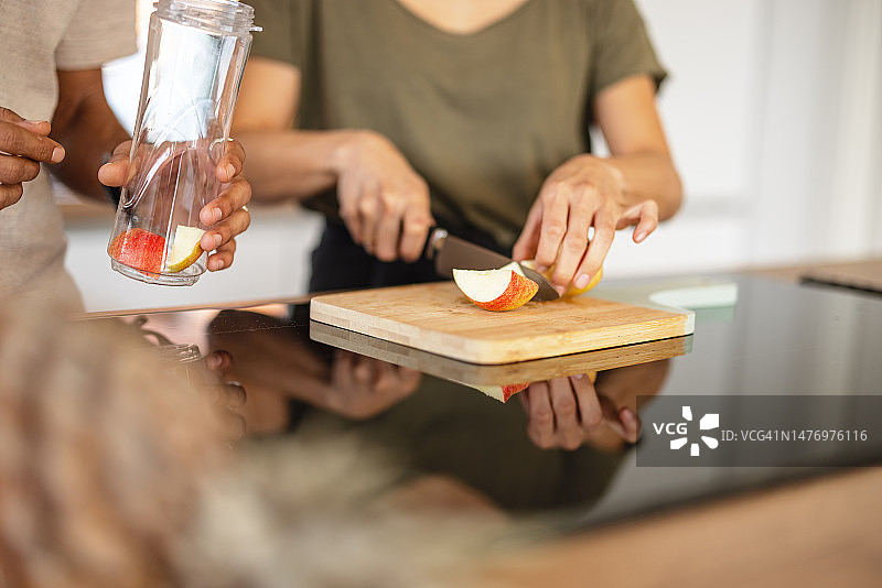 多种族夫妇在家准备健康冰沙特写图片素材