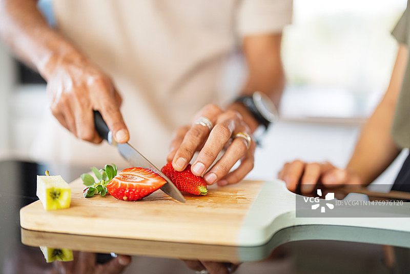 男人在木板上切草莓特写图片素材