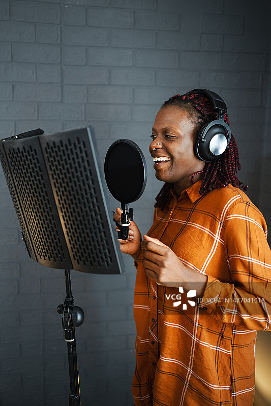 黑人女歌手在录音棚戴耳机录音图片素材