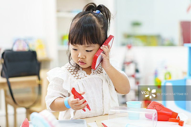 充满积极情绪的亚洲女婴正在学习和享受角色扮演图片素材