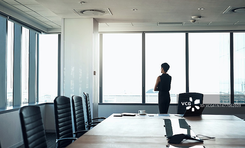 企业、橱窗与成功女性：关于规划、机遇和决策的思考与想法。在会议室中进行思考或展望的女性领导者、管理者和行政人员与顾问或员工图片素材