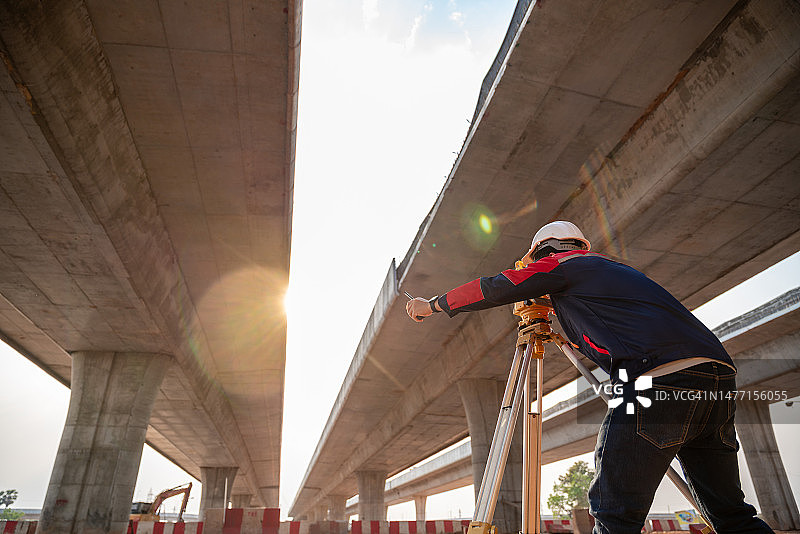 在道路施工现场使用测量设备的土木工程师图片素材