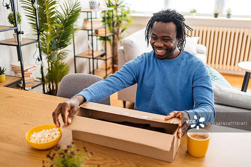 青年男子开箱取出网上购买的新衬衫图片素材