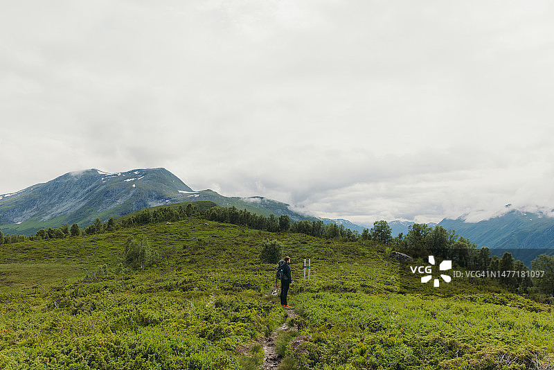 挪威夏季山脉背包男人徒步侧面图片素材