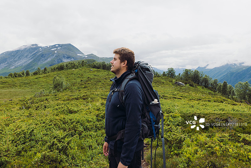 快乐的男人在挪威的夏日山脉中徒步旅行图片素材