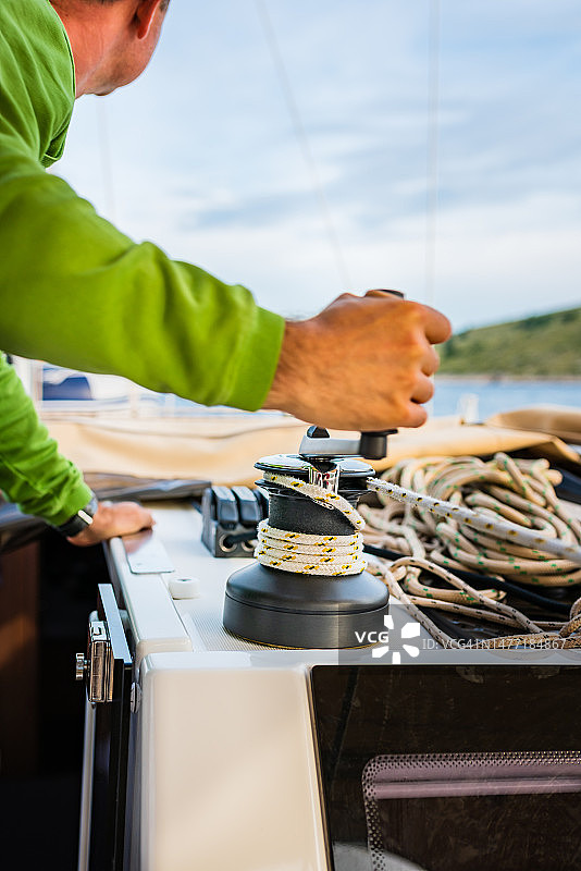 水手用绞盘上的旋转手柄缠绕前帆绳索图片素材